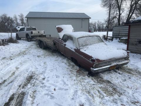 Snow-Covered Vintage Car Ready for Scrap Metal Recycling